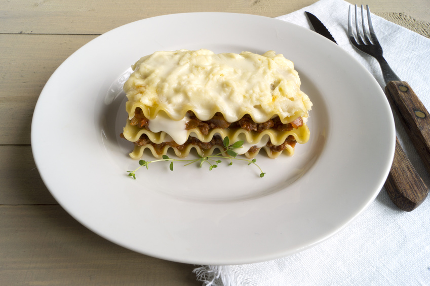 Meat lasagna on a wooden background.