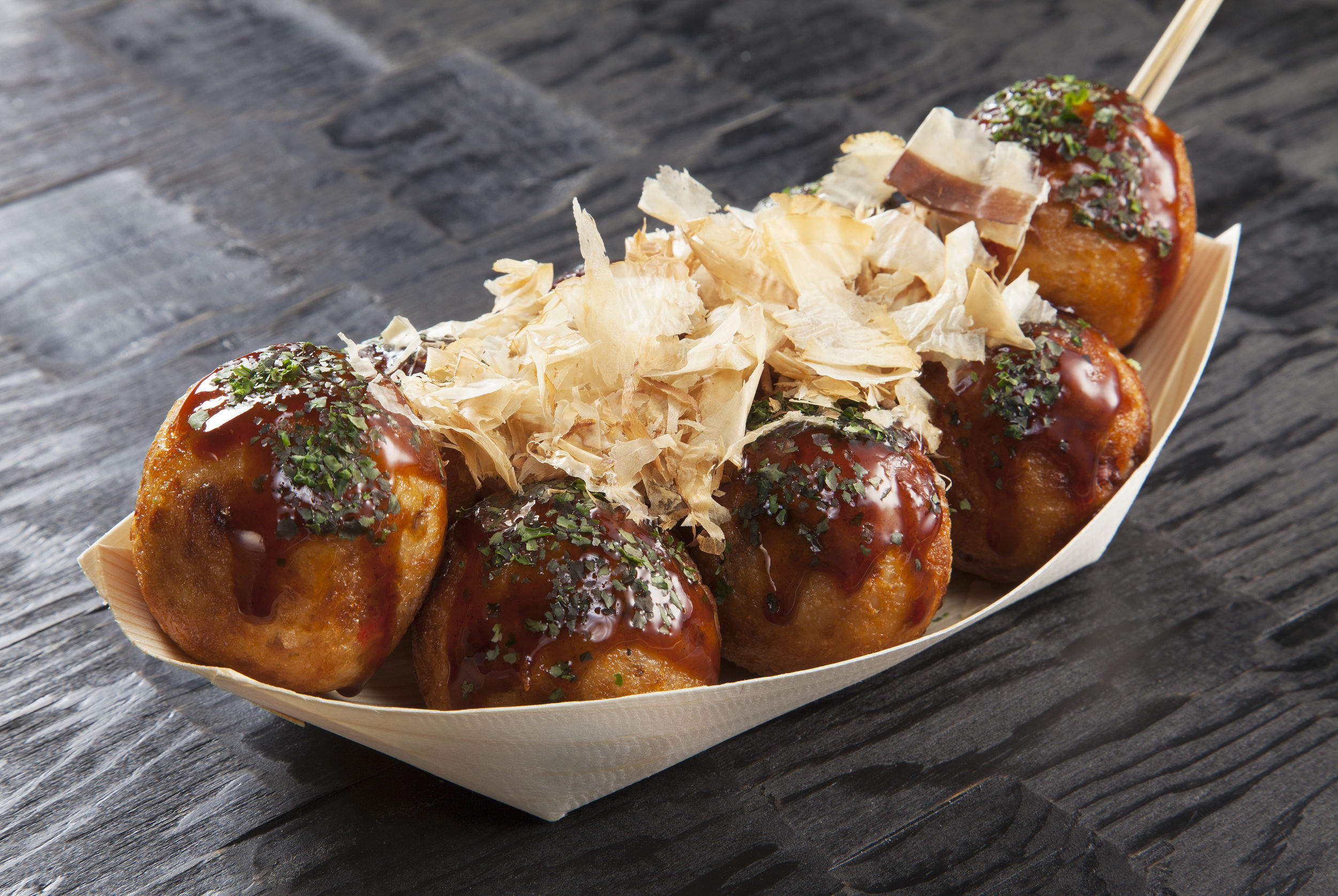 63994359 - takoyaki, octopus balls, japanese food, on a black background